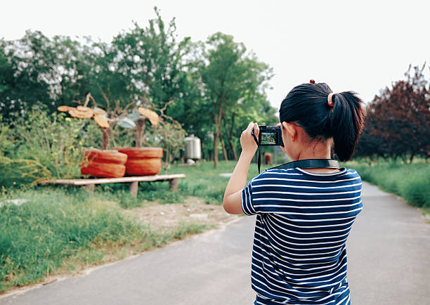 Happy girl holding photo camera in studio