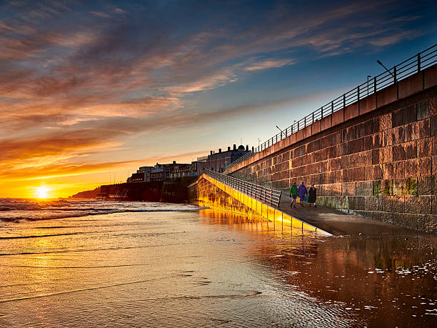 Sea swimmers walking onto beach at sunrise