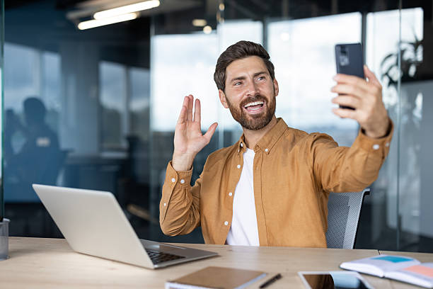 istock Businessman making video call waving hand in office 2245499773
