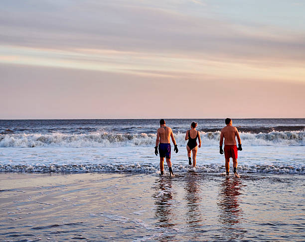 Swimmer walking into the sea at sunrise