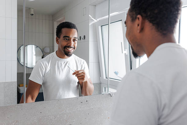 African American man brushing teeth in the bathroom