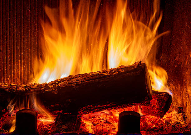 Fireplace burning, wood logs and bright flames. Warm home, heat. Christmas holiday