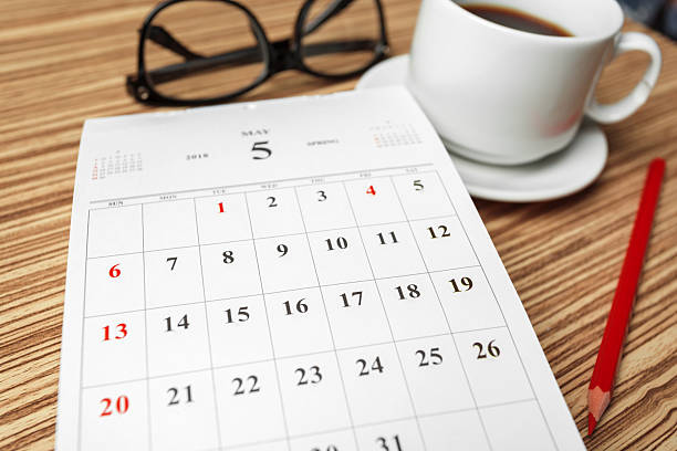 istock Coffee, calendar, and glasses on a wooden table in a cozy workspace setting 2245502753