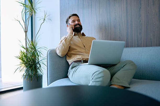 istock Businessman relaxing on office couch having phone call 2245507538
