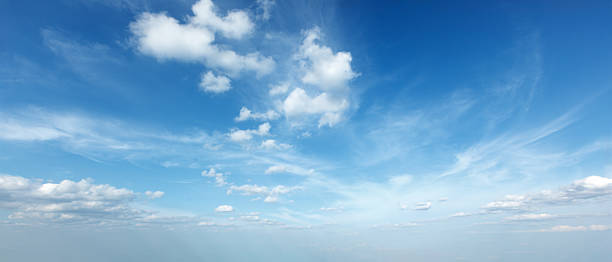A tranquil sky filled with soft clouds under bright blue hues creates a peaceful daytime scene, ideal for relaxation and reflection.