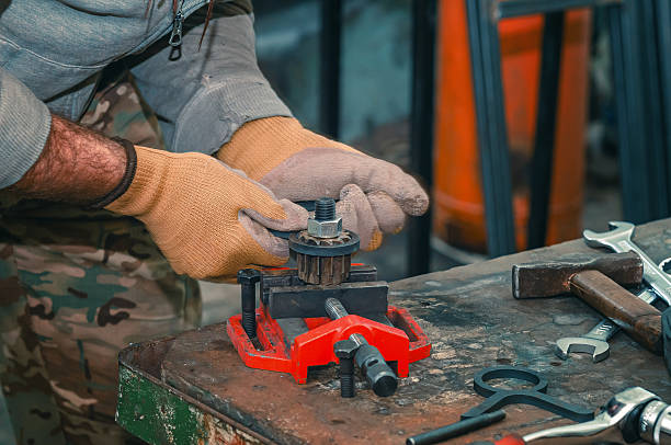 istock Male hands in gloves fix part for welding. Welding vice.with screw handle and cast iron frame 2245515249