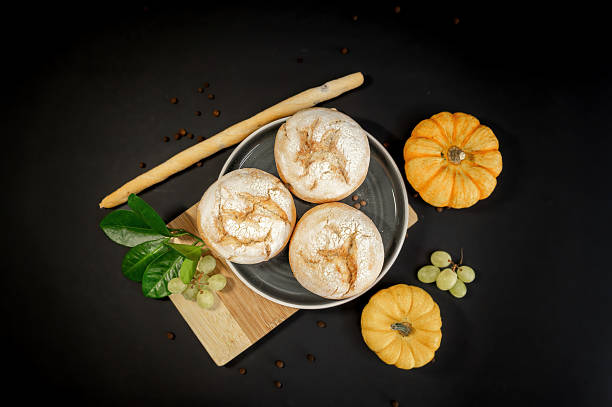 istock Pumpkins and freshly baked buns on black background 2245516857