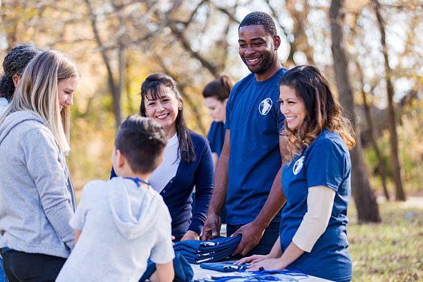 istock Diverse group of people smiling and working together outdoors at a community event 2245519752