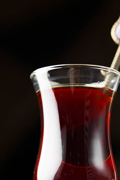 istock Rich dark tea steaming in a delicate glass cup against a dark background 2245520264