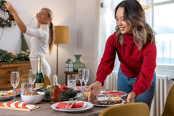 istock Friends celebrate Christmas at home while preparing table for festive New Year dinner 2245521881
