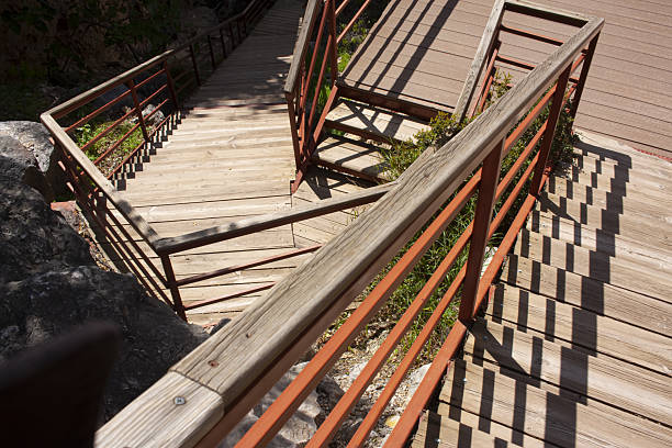 A wooden fence with a stone walkway leading up to it. The fence is made of wood and has a black color