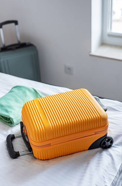 istock Travel suitcase on hotel bed preparing for journey 2245527622
