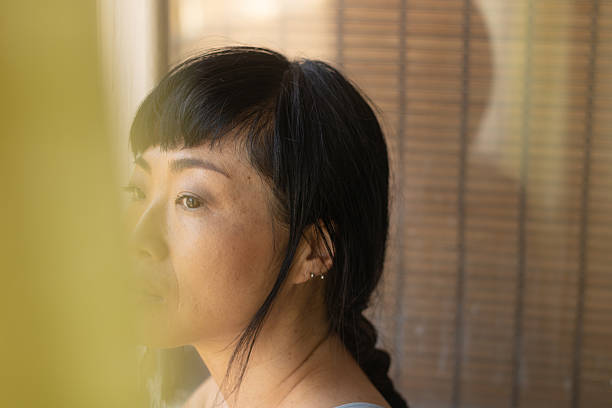istock Thoughtful asian woman looking away daydreaming 2245530220