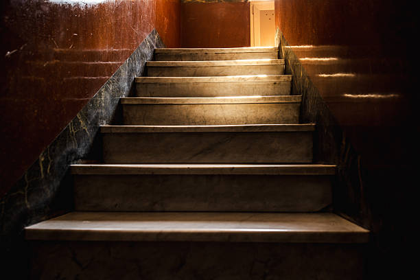 istock Vintage marble staircase inside an old Roman house with warm sunlight casting dramatic shadows on polished walls 2245531461