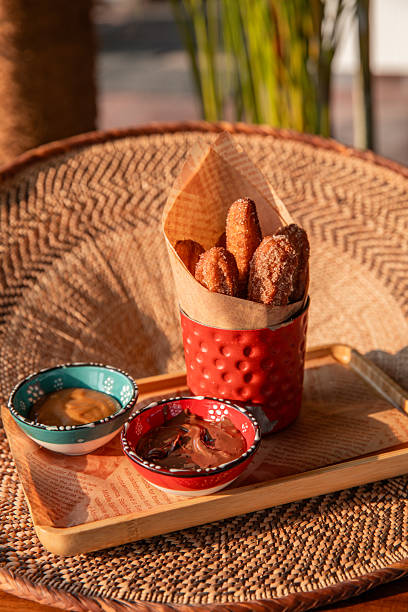 Mexican churros served with chocolate and caramel sauce in sunny Tulum restaurant for dessert