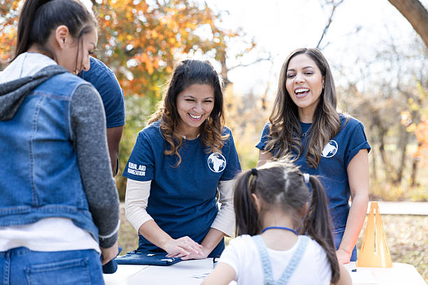 istock Volunteers happily interact with attendees at a community event, spreading awareness for a global aid organization. 2245532171