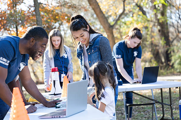 istock Diverse group of volunteers working together outdoors with laptops for an organization. 2245532174