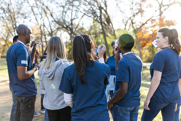 istock Diverse group of people collaborating outdoors for a shared community project on a sunny day. 2245532216