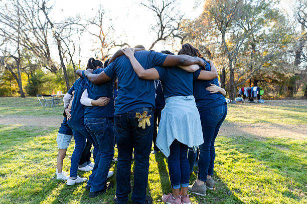 istock Group of diverse people standing in a circle with arms around each other, showing unity. 2245532763