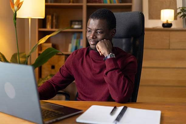 istock Young african manager working from home smiling at laptop screen during video call 2245533189