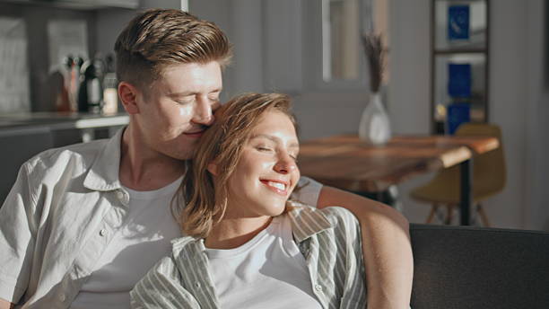 istock Happy partners relaxing sofa together closeup. Affectionate husband embracing 2245538946