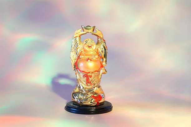 A statue of a smiling Buddha on a pink rainbow background.