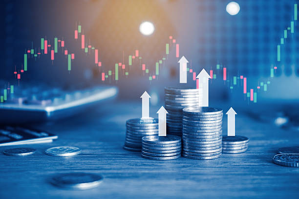 istock Money coin stack on office desk with trading graph and up arrow with blue filter. Business and finance concept. 2245543803