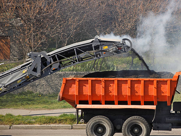 istock Loading crushed hot asphalt onto a truck. Asphalt removal using heavy machinery. Construction and repair of the road. Modern technology of laying a highway with a solid surface. People work 2245547293