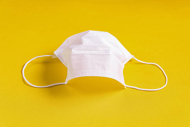 istock Surgical mask over minimalist orange background 2245548249