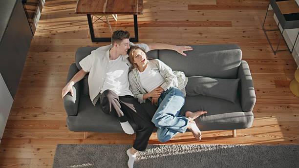 istock Affectionate sweethearts cuddling home in sunlight. Top view happy couple talk 2245548372