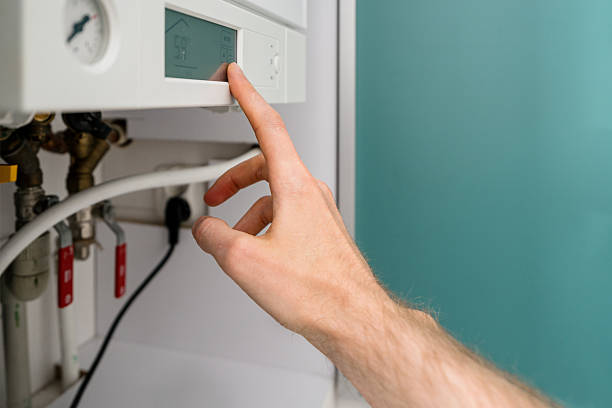 istock Repairman adjusts gas boiler settings in modern bathroom for efficient heating 2245548809