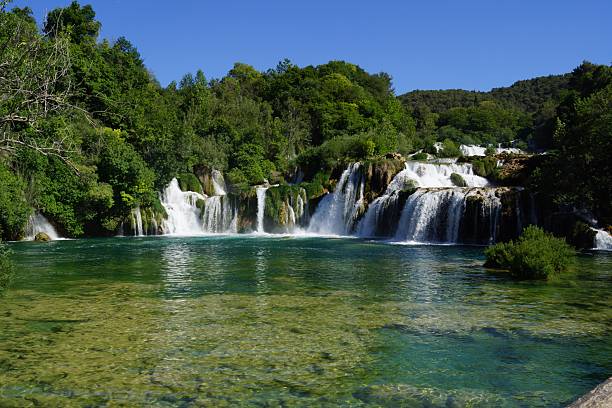 istock Majestic Waterfall Cascading into Clear Turquoise Pool in Lush Forest 2245550368