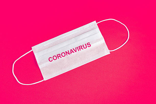 istock Surgical mask over minimalist orange background 2245551851
