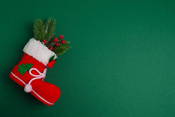 Christmas holiday concept. Santa's boot with decorations on green background. Space for text