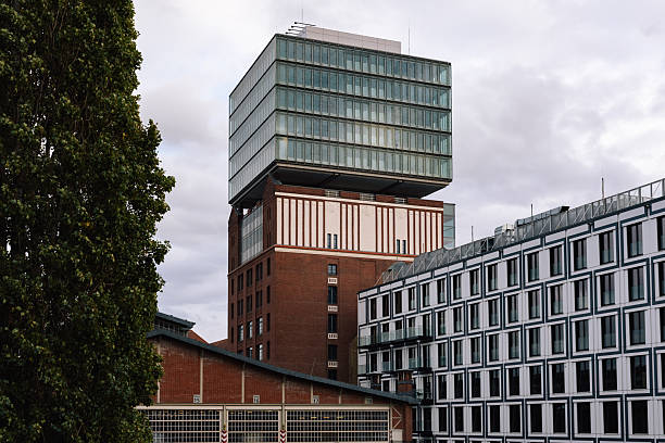 Berlin, Germany – A contemporary office building combining brick and glass stands against a cloudy sky, symbolizing the city’s mix of industrial heritage and modern design.