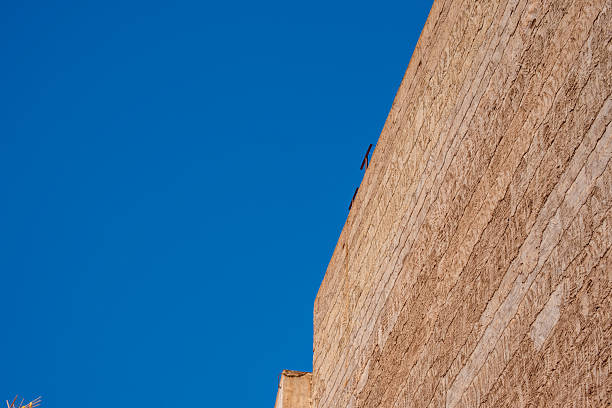 Minimalist architecture against clear blue sky: modern concrete wall perspective.
