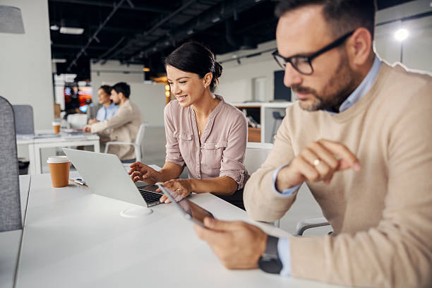 istock Colleagues collaborating on laptop and digital tablet in office 2245556465