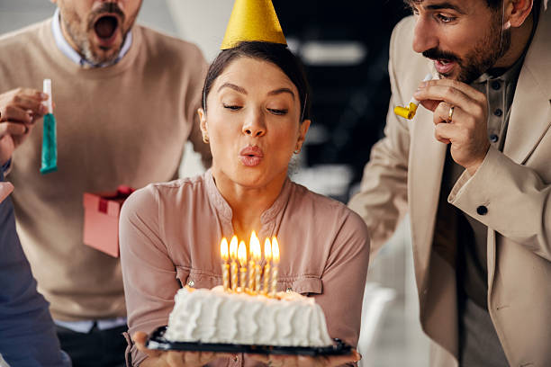 istock Colleagues celebrating birthday in office blowing out candles 2245557188