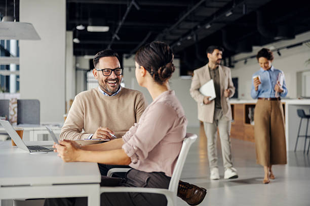 istock Colleagues collaborating and smiling in modern office 2245557675