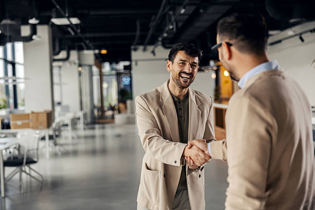 istock Businessmen shaking hands making partnership deal in office 2245557797
