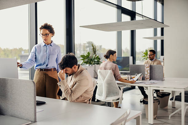 istock Stressed businessman having a headache in modern office 2245557881