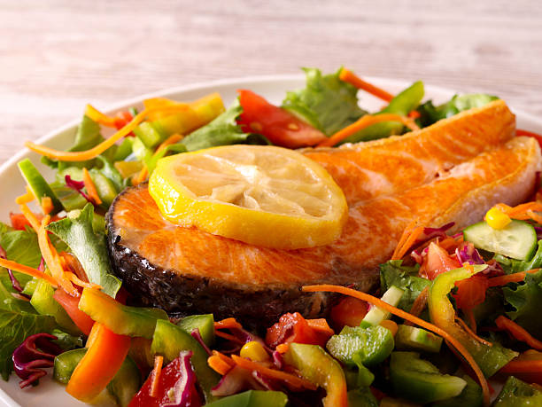istock salmon with salad on plate 2245559410