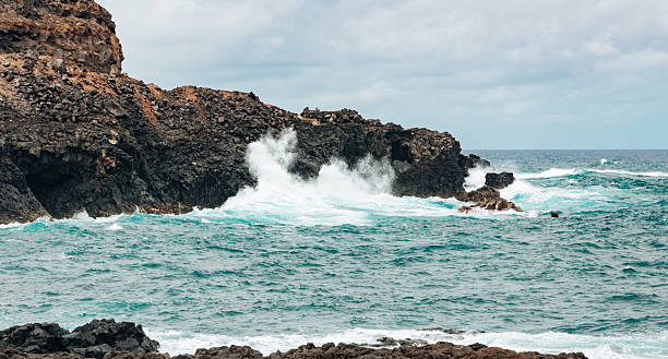 istock Background: volcanic coastal cliff with waves on a cloudy day. 2245560426