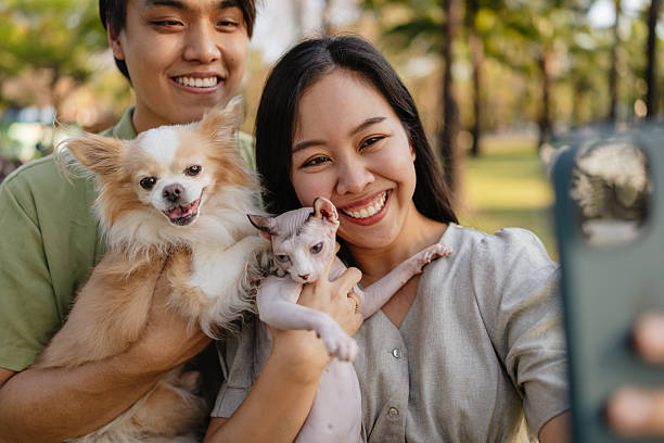 istock Smiling couple taking selfie with pets in park 2245560632