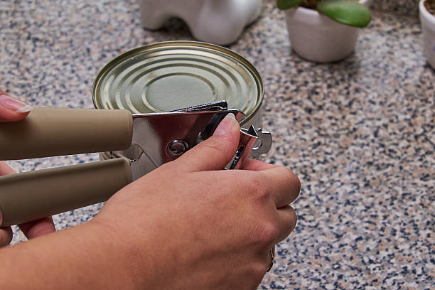 istock A can of preserves with a can opener, ready to be opened, on a dining table. 2245561259