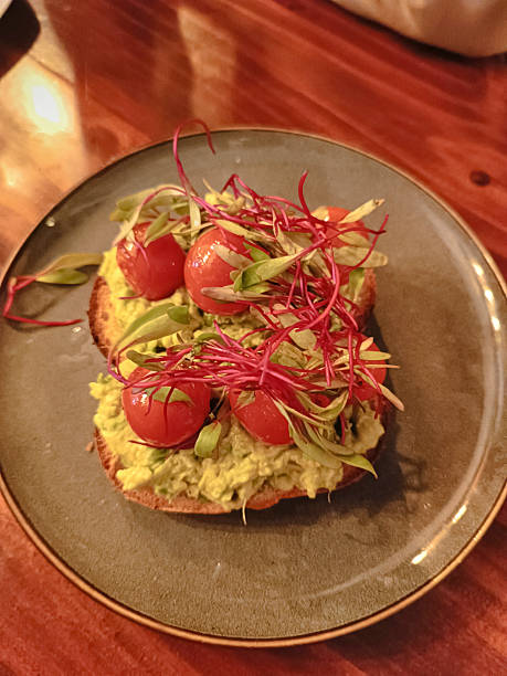 istock Breakfast sandwich: avocado, tomato, garnished with basil and kale 2245561422