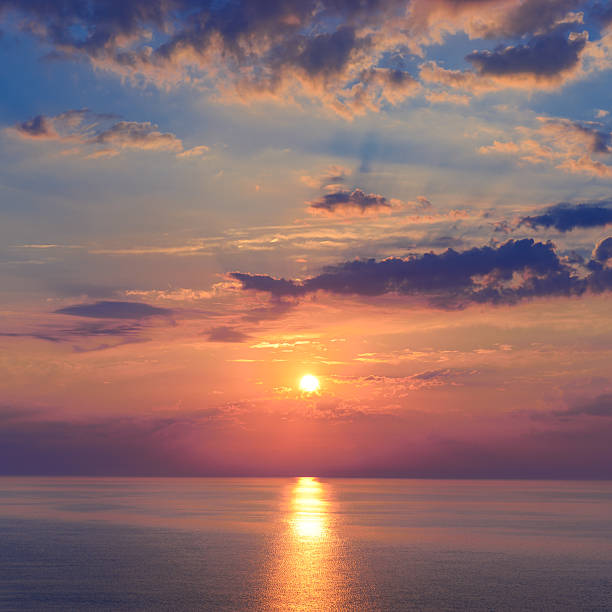 istock Evening sky with vibrant sunset colors above sea surface, reflected light creating calm atmosphere 2245562827