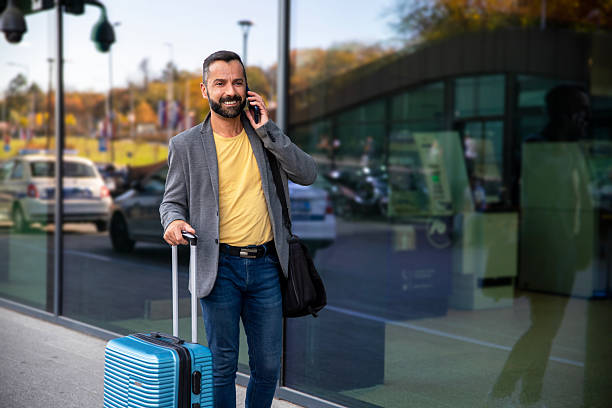 istock Businessman walking with suitcase outside office building 2245564292