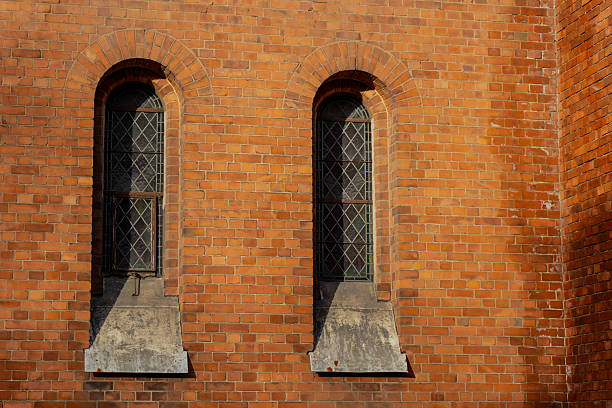 istock Old brick wall with tall arched windows and decorative frames in Riga representing historic architecture, urban heritage, craftsmanship and traditional building design with preserved facade details 2245564583