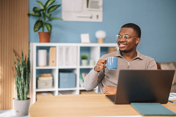 istock Man smiling and pondering over laptop screen 2245566334